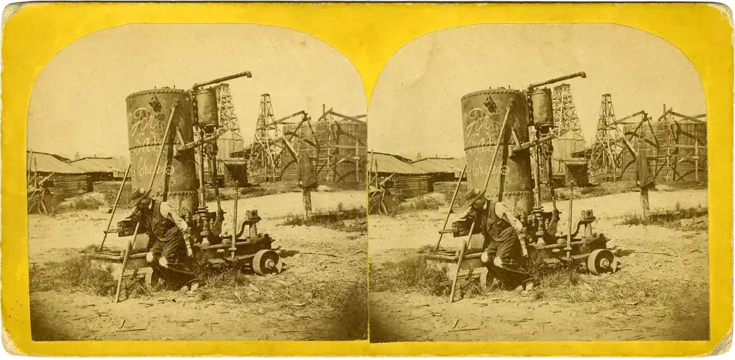 A stereograph of an early oil drilling site, circa 1866. A worker in the foreground sits next to equipment with a sign on it that says "for sale cheap."